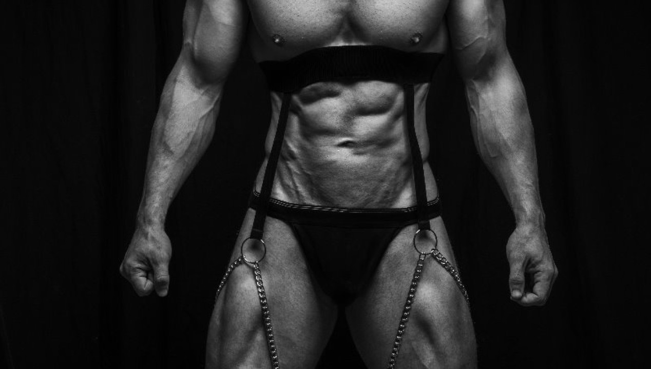 sexy Bodybuilder im schwarzen Harness mit Ketten